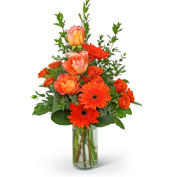 Orange roses and gerbera daisies in a clear glass vase