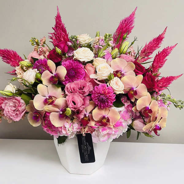 Pink and cream floral arrangement in a white vase