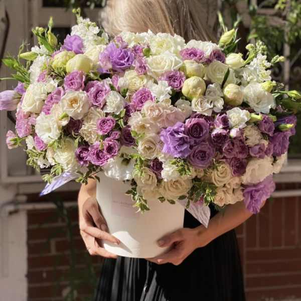 Large bouquet of purple, white, and cream roses in a white box