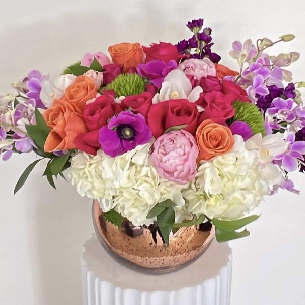 Bright mixed bouquet in a copper vase with pink, orange, white, and purple flowers