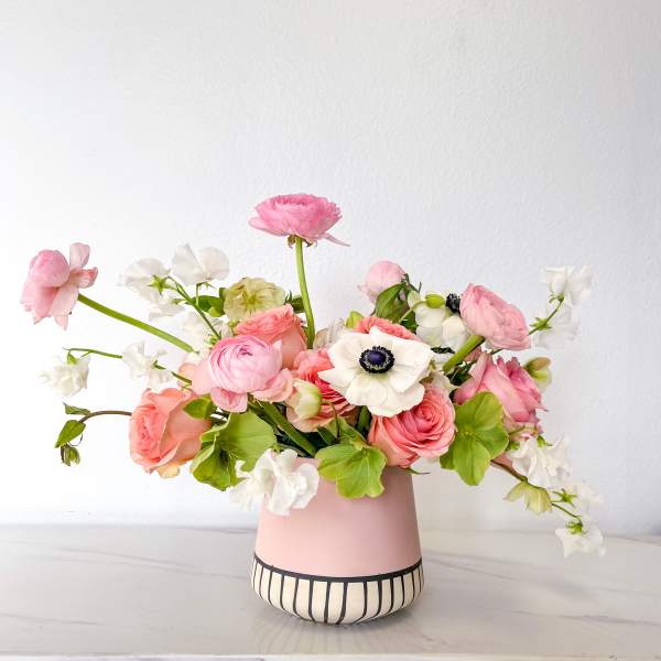 Pink and white flower arrangement in a pink vase