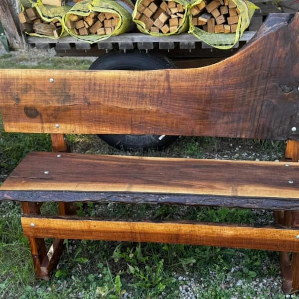 Wooden bench with a live-edge backrest and seat outdoors