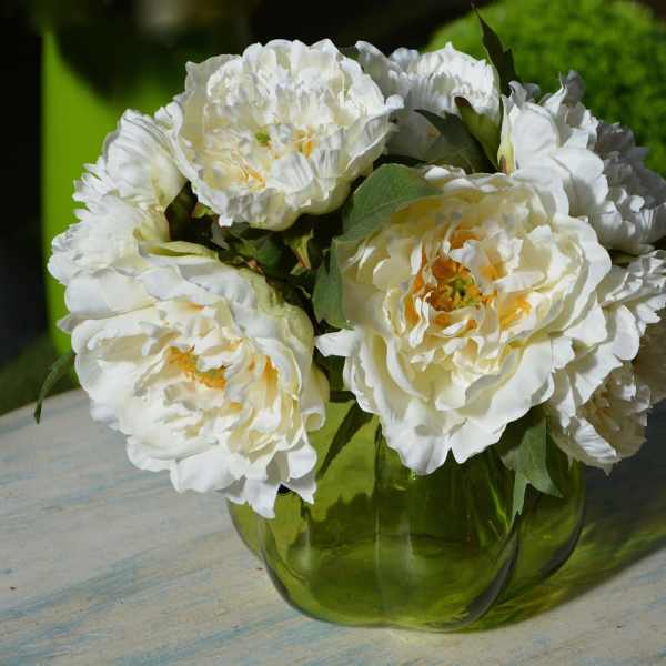 White peony bouquet in a green glass vase