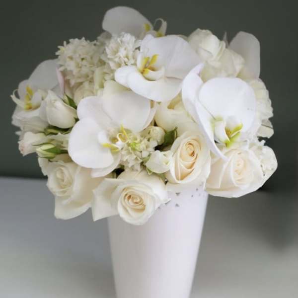 White floral bouquet in a tall white vase