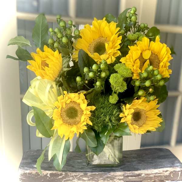 Bouquet of yellow sunflowers in a clear glass vase