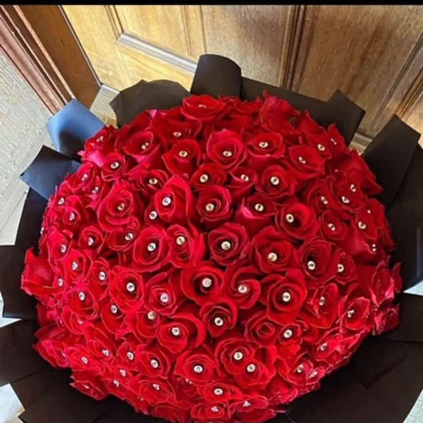 Large round bouquet of red roses wrapped in black paper