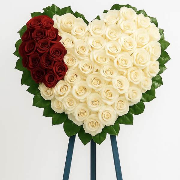 Heart-shaped rose arrangement on an easel with red and white roses