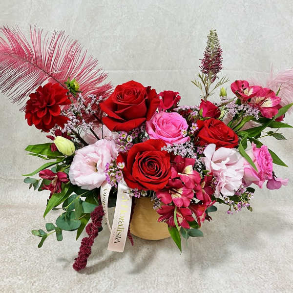 Mixed bouquet of red and pink roses in a gold vase