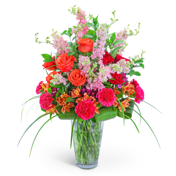 Bright mixed bouquet in a clear glass vase with pink and orange flowers