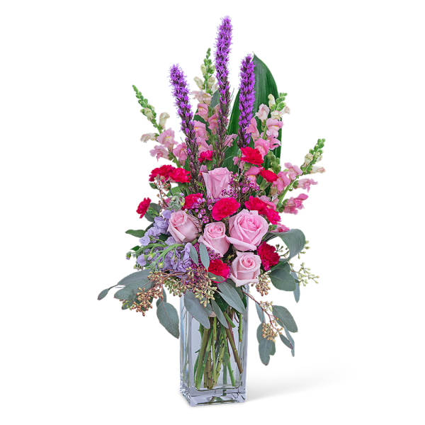 Pink and purple mixed flower arrangement in a clear glass vase