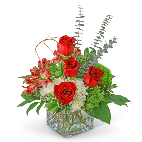 Red roses and pink flowers in a clear square vase