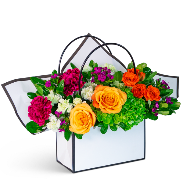 Bright mixed flower arrangement in a white handled gift box