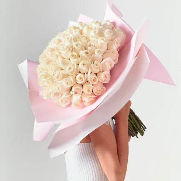 Large bouquet of pale cream roses wrapped in pink paper