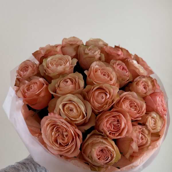 Bouquet of peach roses wrapped in pale pink paper