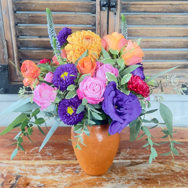 Colorful mixed bouquet in an orange vase