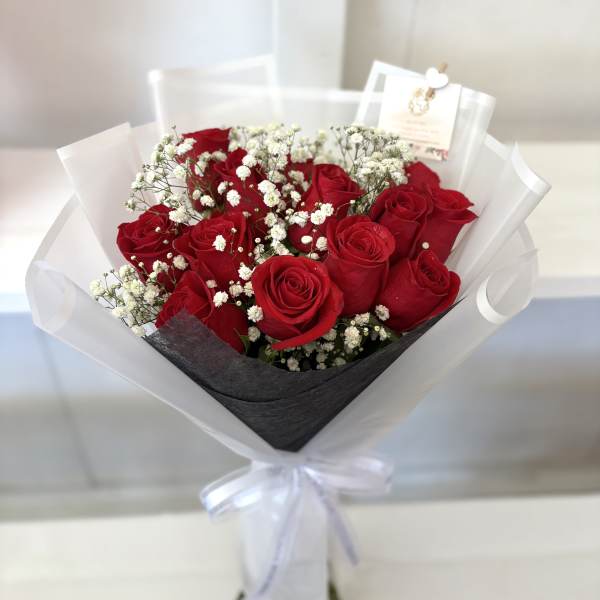 Bouquet of red roses with white baby's breath in white wrap
