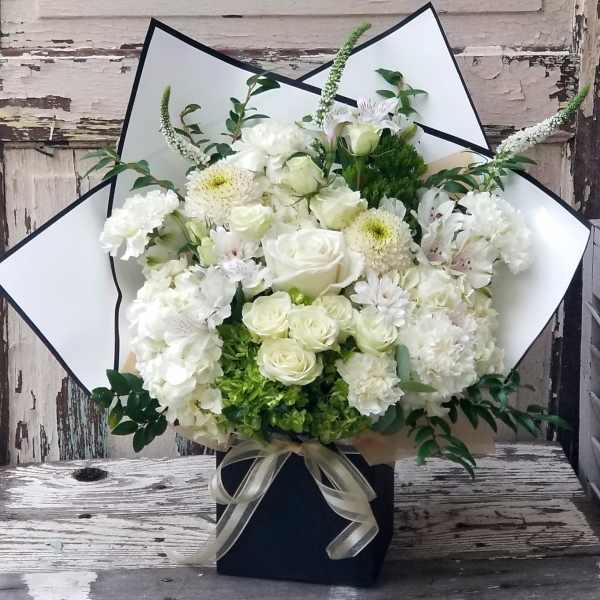 White floral bouquet with roses and chrysanthemums in a black box