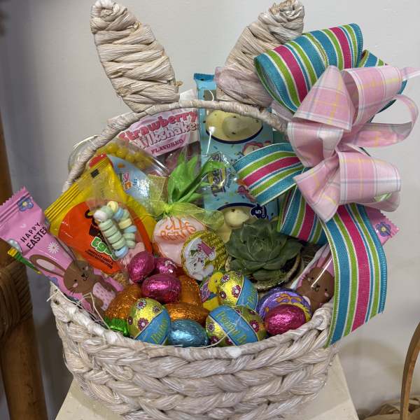 Easter gift basket with candies, a small succulent, bunny-ear handle, and a large striped bow