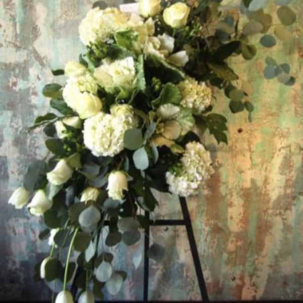 White floral spray with roses and hydrangeas on a stand
