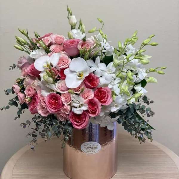 Pink and white floral arrangement in a metallic vase