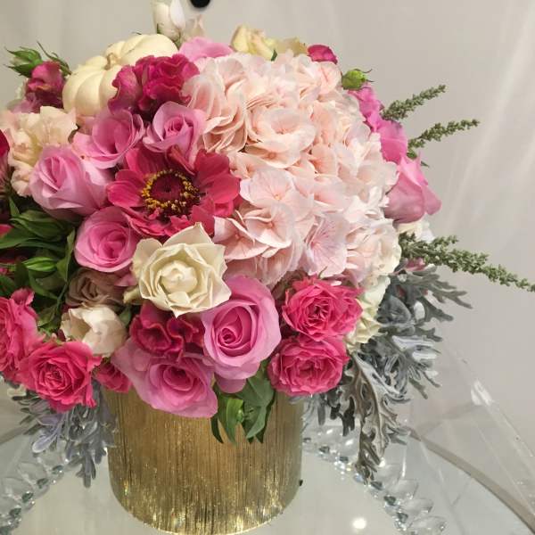 Pink and cream floral arrangement in a gold vase