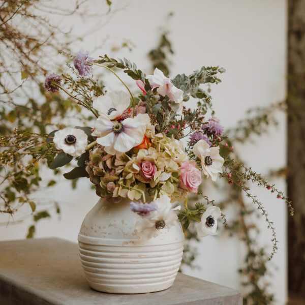 Loose bouquet of white and pink flowers in a white vase
