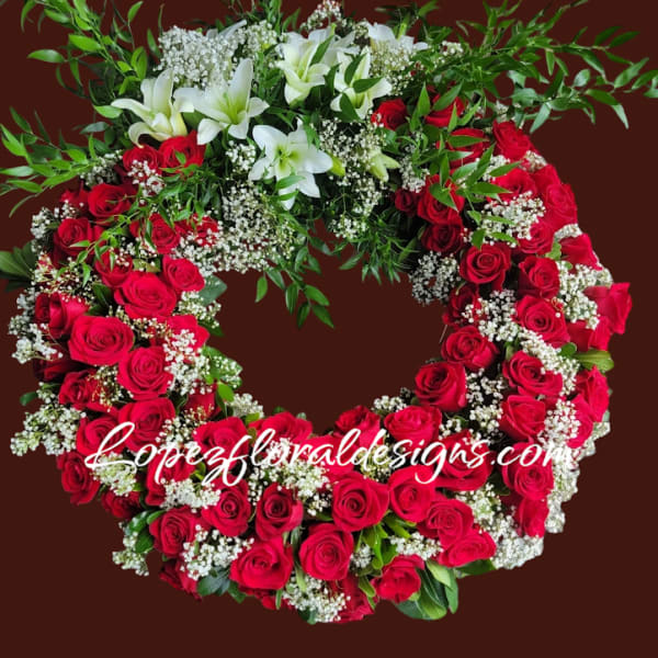 Heart-shaped wreath of red roses and white lilies with baby's breath