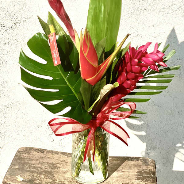 Tropical bouquet with red ginger flowers in a glass vase