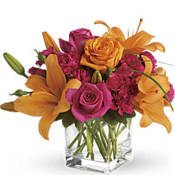 Pink roses and orange lilies arranged in a clear glass vase