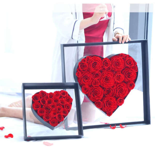 Two heart-shaped rose arrangements in black frames, one large and one small