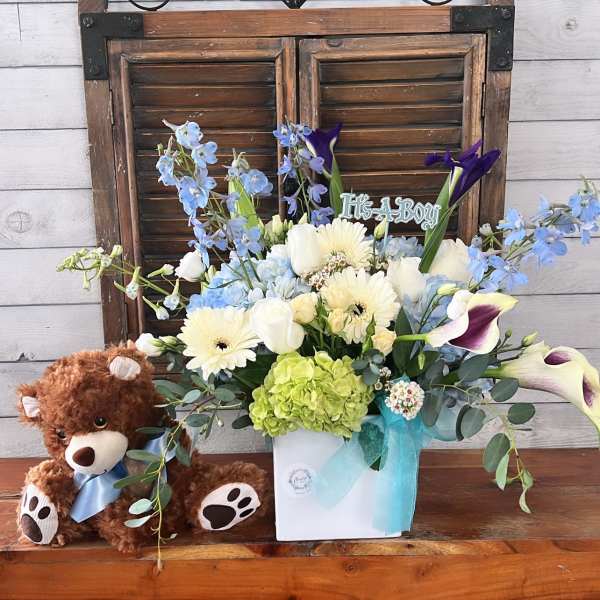 Bouquet in a white box with a teddy bear and blue ribbon