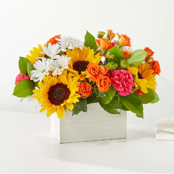 Bright mixed bouquet in a white box with sunflowers, roses, daisies, and carnations