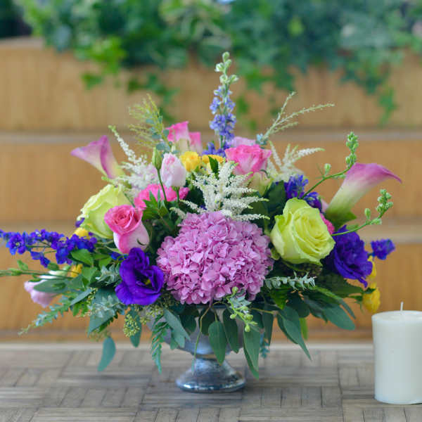 Mixed bouquet in a glass vase with pink, purple, and green blooms