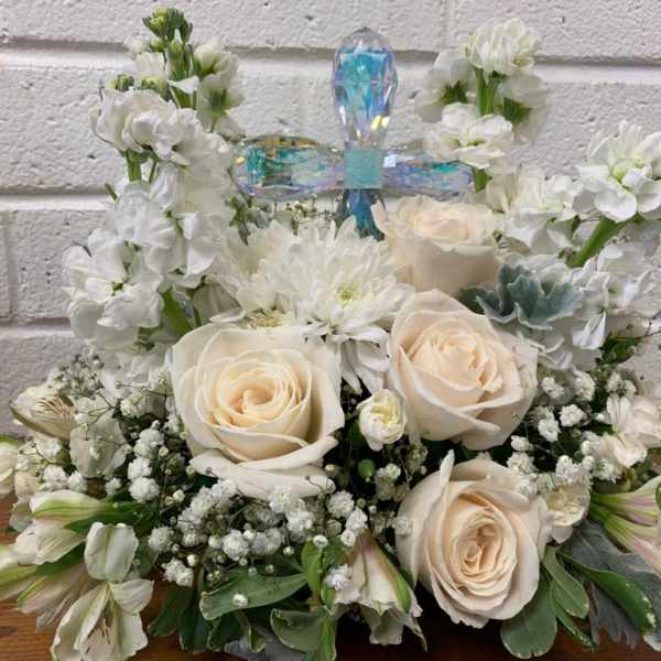 White floral arrangement with cream roses and a crystal cross topper