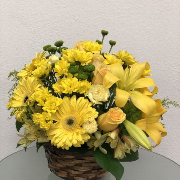 Yellow mixed flower arrangement in a woven basket
