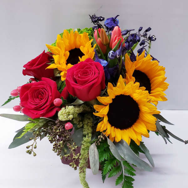 Bouquet of red roses and sunflowers with purple blooms