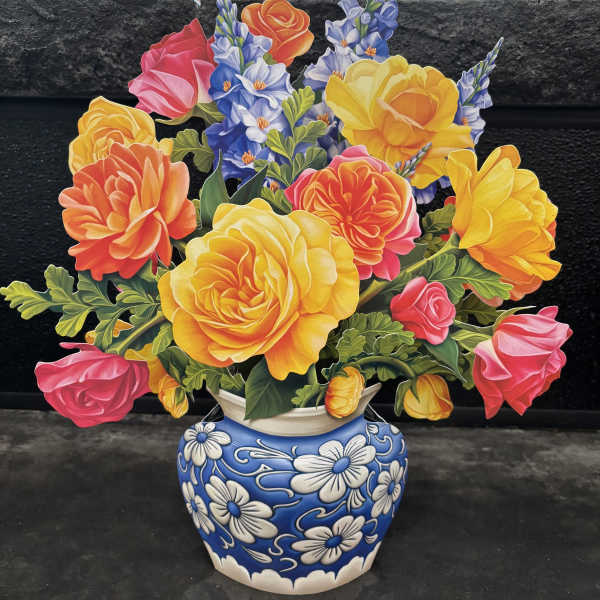 Colorful bouquet of roses and blue flowers in a blue-and-white vase