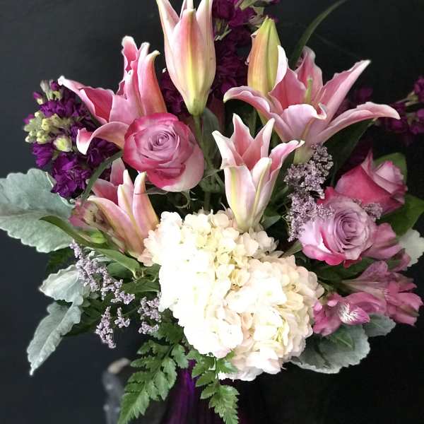 Pink lilies, roses, and white hydrangea in a bouquet
