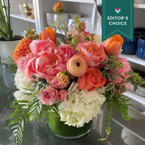 Pink and orange mixed flower arrangement in a glass vase