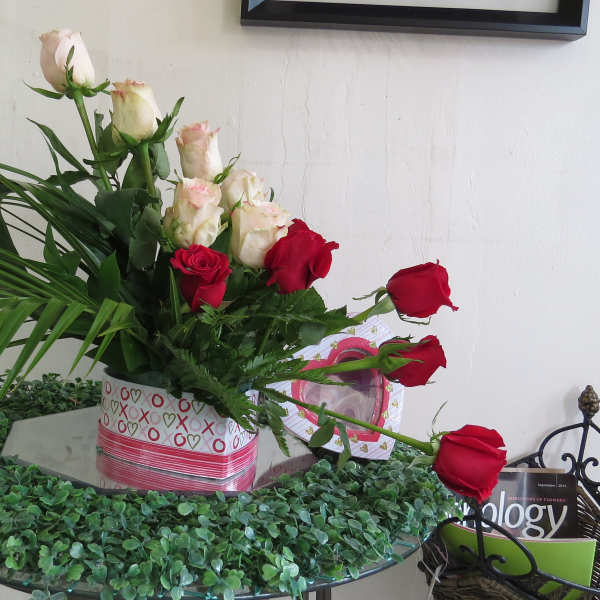 Bouquet of red and white roses in a heart-patterned box