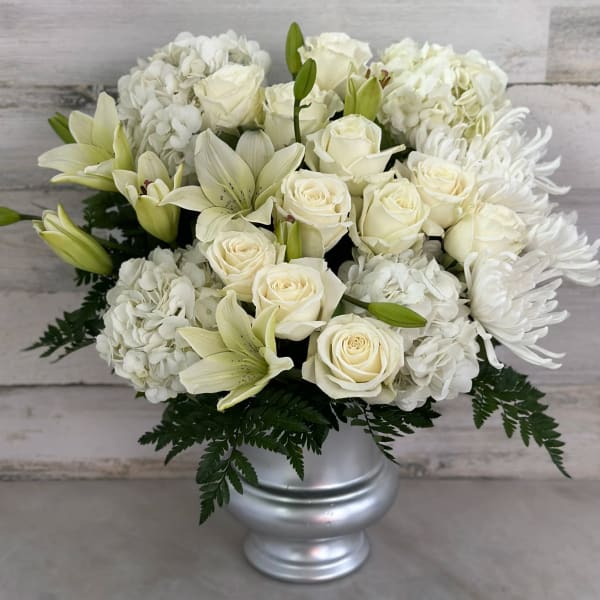 White roses, lilies, hydrangeas, and chrysanthemums in a silver vase