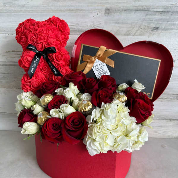 Red rose teddy bear and mixed roses in a heart-shaped gift box