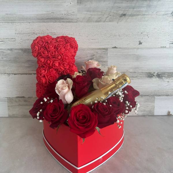 Heart-shaped rose arrangement with a champagne bottle in a red box