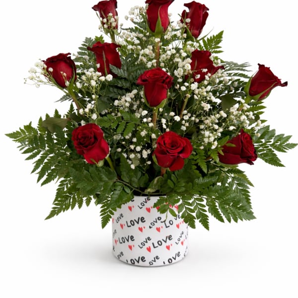 Red roses arranged with white baby's breath in a heart-patterned container