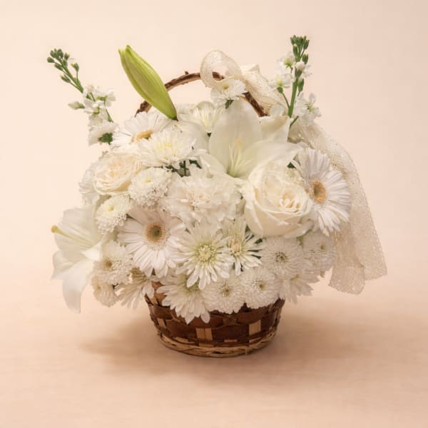 White floral basket arrangement with lilies, roses, and daisies