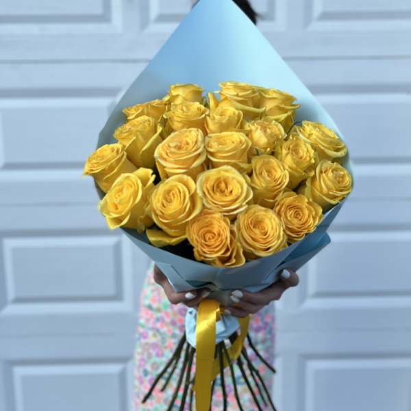 Bouquet of yellow roses wrapped in blue paper