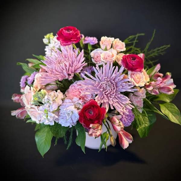 Bouquet of pink and lavender flowers in a white vase