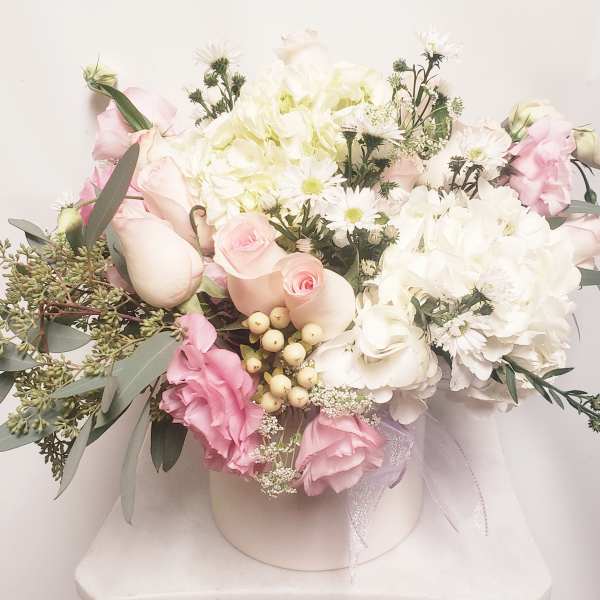 Pink and white bouquet in a round box with a ribbon