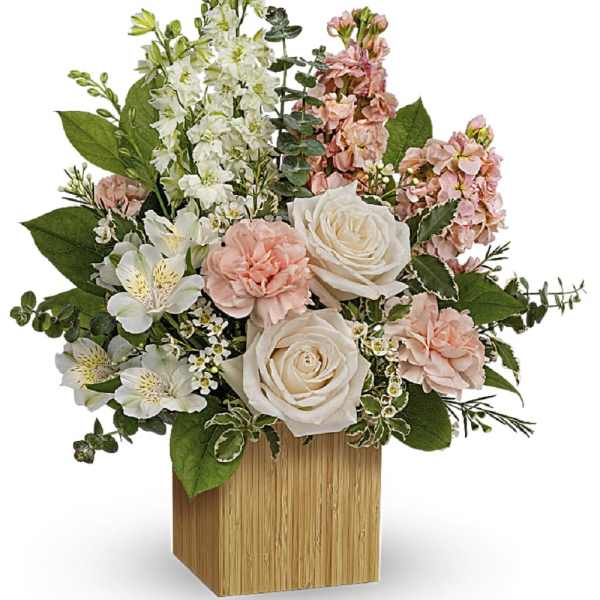 Pink and white floral arrangement in a wooden cube vase