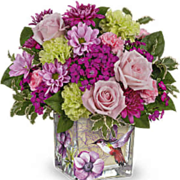 Pink and purple bouquet in a square glass vase with a bird design